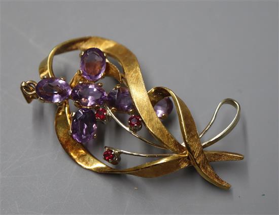 An 18ct white and yellow gold openwork ruby-set ribbon brooch and a 9ct gold and amethyst cross pendant.